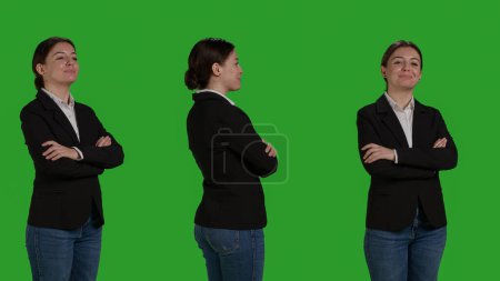 Téléchargez les photos : Close up of young accountant wearing formal suit in studio, acting positive and confident over green screen backdrop. Corporate worker being cheerful, company employee smiling on camera. - en image libre de droit
