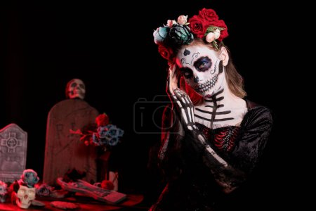 Photo for Lady of dead model with santa muerte costume looking like la cavalera catrina holy skull with make up. Wearing mexican halloween body art to celebrate dios de los muertos in studio. - Royalty Free Image