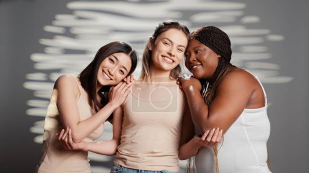 Photo for Interracial friends expressing body acceptance and woman power, feeling beautiful with luminous skin on camera. Happy flawless girls embracing body imperfections, curvy and skinny ladies. - Royalty Free Image