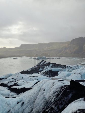 Foto de Vatnajokull masivos glaciares tapas cerca de montañas nevadas, bloques de hielo masivos con hielo transparente agrietado. Formaciones rocosas heladas con iceberg en forma de diamante, desierto icelandés. - Imagen libre de derechos