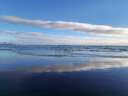Foto de Frente al mar con playa de arena negra en la naturaleza de iceland, hermoso frente a la playa majestuoso con las olas rompiendo, paisaje nórdico increíble con costa en iceland. Entorno mágico. - Imagen libre de derechos