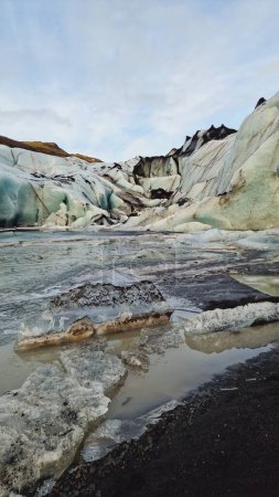 Foto de Escénica capa de hielo glaciar vatnajokull, fantástica laguna glaciar azul cubierta de heladas en la región icelándica. Increíbles icebergs nórdicos y rocas glaciares agrietadas en paisajes helados. - Imagen libre de derechos