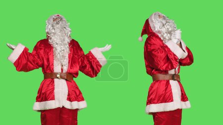 Photo for Young saint nick character pray to god in studio, acting spiritual and holding hands in a prayer. Santa claus praying over greenscreen backdrop, christmas eve holiday celebration. - Royalty Free Image