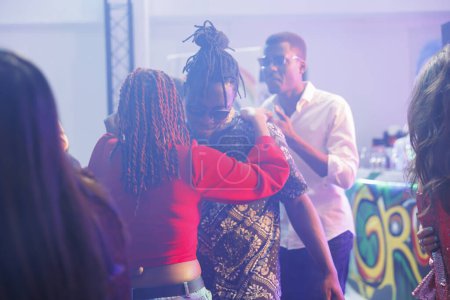 Romantic couple dancing together while partying in nightclub. African american boyfriend and girlfriend embracing, showing love and affection on dancefloor while clubbing