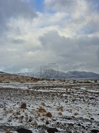 Photo for Snowy mountains and wintry pastures in iceland nature, beautiful nordic scenery covered in snow. Fantastic massive rocky mountaintops and brown frosty fields alongside countryside. - Royalty Free Image