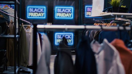 Photo for Black friday best deals on products. Modern clothing items being on promotion, various brands merchandise. Empty shopping center filled with red price tags, november discount offers. - Royalty Free Image