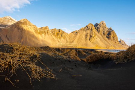 Téléchargez les photos : Magnifique emplacement naturel sur la péninsule scandinave avec des hauts plateaux du vestrahorn et une plage de sable noir à Stokknes. Pentes massives et rivage incroyable en Islande, scène paradisiaque. - en image libre de droit