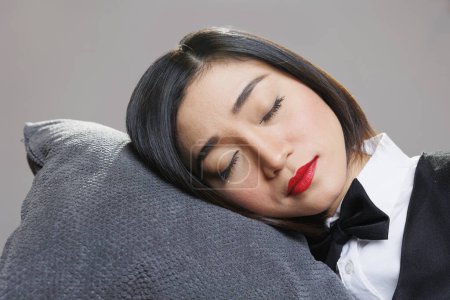 Photo for Tired sleepy woman receptionist with closed eyes lying head down on pillow. Restaurant catering service young attractive exhausted asian waitress sleeping and relaxing closeup - Royalty Free Image