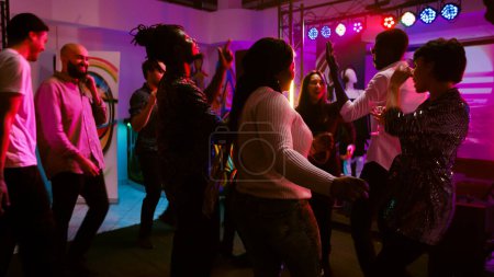 Photo for POV of woman dancing with friends on dance floor, having fun on night out and drinking alcohol. Cheerful girl partying with diverse people at nightclub or discotheque. Handheld shot. - Royalty Free Image