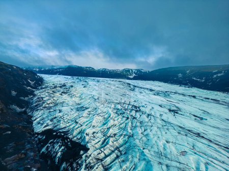 Foto de Impresionantes glaciares Vatnajokull con trozos de hielo y grandes superficies heladas dentro del desierto nórdico, tiro con drones. iceberg en forma de diamante con agua congelada cerca de las montañas cubiertas de escarcha. - Imagen libre de derechos