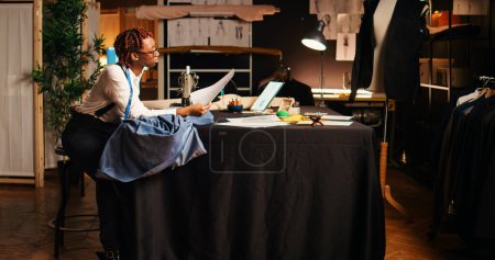 Photo for Seamstress using sewing machine to design and craft fashion items at workstation. Professional tailor working with handcraft equipment and tools, creating tailored custom made clothes. - Royalty Free Image
