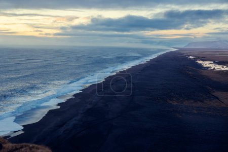 Foto de Costa norte con playa de arena negra, vista excepcional de la naturaleza con olas rompiendo. Paraíso congelado en Islandia con maravillosas playas con rocas y aguas, junto a la carretera. - Imagen libre de derechos