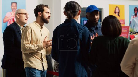 Photo for Anxious shoppers going crazy on black friday event, fighting to be first inside clothing store to receive special offers. Aggressive clients pushing red tape, arguing with agent. Handheld shot. - Royalty Free Image