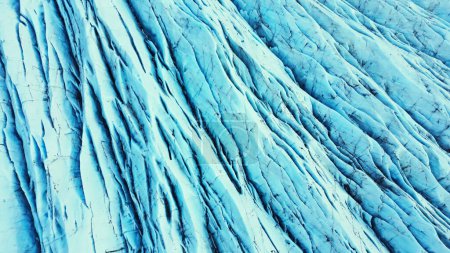 Téléchargez les photos : Vue aérienne de blocs de glaciers bleus sur la calotte glaciaire du vatnajokull en Islande, d'icebergs massifs et de crevasses créant un paysage scandinave naturel. Rochers glaciaires spectaculaires et lagune des glaciers. Mouvement lent. - en image libre de droit