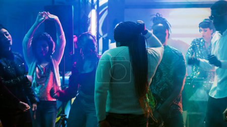 Photo for African american person having fun, dancing in the club at social gathering with funky people. Cheerful group of friends listening to music, enjoying party on the dance floor. Tripod shot. - Royalty Free Image