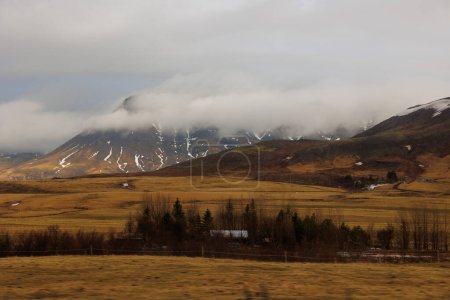 Foto de Coche en coche en la capital de la calle reykjavik para ver el paisaje de campo icelandés durante el viaje por carretera alrededor de los campos. Espectacular aventura nórdica en carreteras de Islandia, colinas y montañas escandinavas. - Imagen libre de derechos