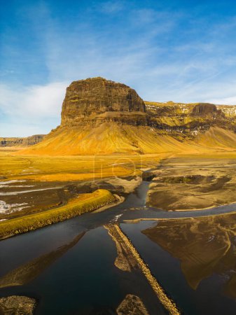 Téléchargez les photos : Photo par drone d'une crête montagneuse étonnante en Islande, montrant une pente énorme avec des courbes rocheuses à côté des pâturages glaciaires. Superbe paysage glaciaire avec la nature arctique et les champs. - en image libre de droit