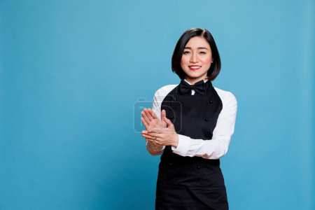 Photo for Cheerful asian waitress applauding and looking at camera with happy expression. Smiling joyful woman receptionist making applause, congratulating and celebrating success portrait - Royalty Free Image