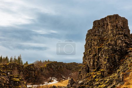 Foto de En el parque nacional de hielo, impresionantes bordes de tierras altas formadas por piedra maciza y creado colinas rocosas volcánicas. Valle de Thingvellir escandinavo en Islandia, magnífica región natural. - Imagen libre de derechos