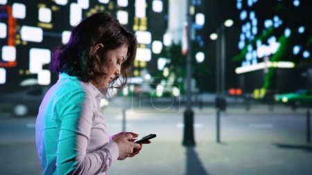 Foto de Adulto en smartphone caminando cerca del centro de la ciudad, mirando los mapas para obtener direcciones en el paseo nocturno. Mujer relajándose con paseos nocturnos leyendo textos, mirando rascacielos en el centro. Disparo de mano. - Imagen libre de derechos