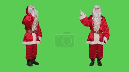 Téléchargez les photos : Caractère Saint Nick exprimant rejet et refus, ne montrant aucun symbole sur la caméra. Père Noël se sentant mécontent et déçu, faisant signe de désaccord et de déception sur l'écran vert. - en image libre de droit