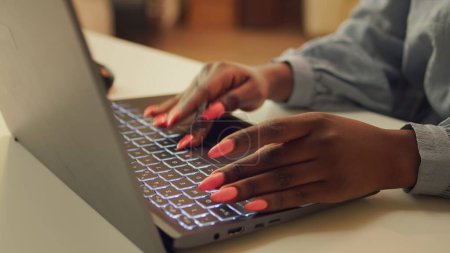 Téléchargez les photos : Femme dactylographiant des informations sur un ordinateur portable, travaillant à résoudre des tâches de projet Web à la maison. Blogueur afro-américain écrivant la ligne d'histoire pour le télétravail, développeur indépendant. Gros plan. - en image libre de droit