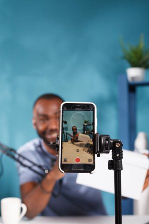 Photo for African american blogger showing giveaway gift box on smartphone screen closeup. Vlogger promoting product while announcing online contest with prize and streaming using mobile phone - Royalty Free Image