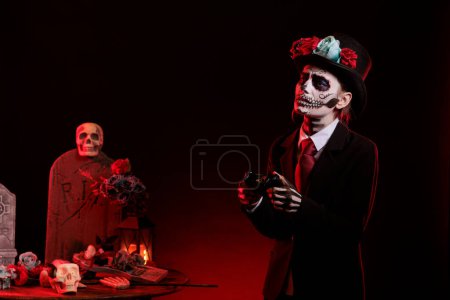 Photo for Goddess of death losing at video games play feeling sad, wearing holy day of the dead costume to celebrate mexican tradition. Woman playing online competition with la cavalera catrina make up. - Royalty Free Image
