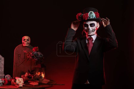 Téléchargez les photos : Beau modèle en costume avec crâne pour célébrer les vacances mexicaines traditionnelles avec la déesse du costume de la mort. La cavalera catrina célébration de la culture avec art corporel sur fond noir. - en image libre de droit