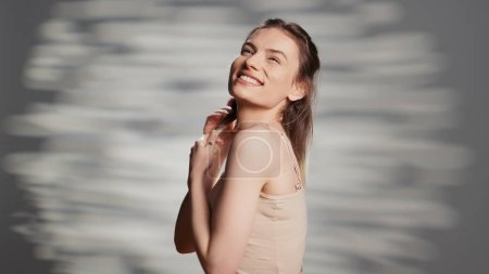 Téléchargez les photos : Beautiful woman embracing imperfections with bare skin, posing with natural look on camera. Smiling confident model creating empowering and uplifting beauty campaign, elegance. - en image libre de droit