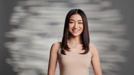 Photo for Asian model with glowing look posing for beauty ad on camera, feeling beautiful promoting self confidence. Flawless woman with radiant bare complexion advertising skincare cosmetics. - Royalty Free Image