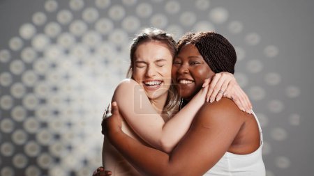 Téléchargez les photos : Diverse women smiling and posing on camera, creating campaign for body positivity and diversity. Beauty models with different skintones and body shapes promoting wellness and self acceptance. - en image libre de droit