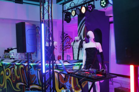Photo for Dj controller and mannequin in headphones on stage in nightclub with spotlights. Musician equipment for electronic music performance and disco party in empty club at night - Royalty Free Image