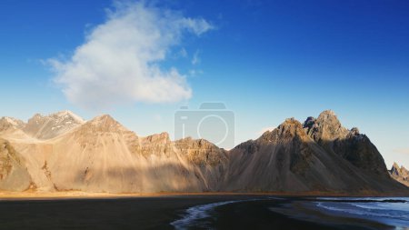 Photo for Drone shot of vestrahorn mountains in iceland, stokksnes beach peninsula creating majestic icelandic scenery. Beautiful nordic landscape with black sand beach, scenic route. Slow motion. - Royalty Free Image