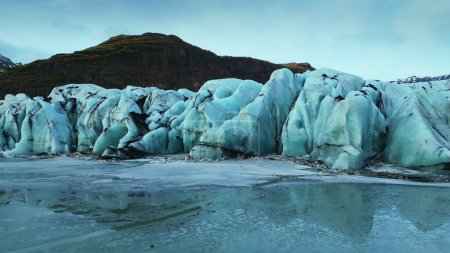 Téléchargez les photos : Drone shot of vatnajokull glacier caves, nordic massive ice rocks next to frozen water in icelandic scenery. Des icebergs majestueux creusent des crevasses en Islande. Ferme là. Mouvement lent. - en image libre de droit
