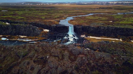 Téléchargez les photos : Vue aérienne de la cascade d'oxarafoss en Islande, spectaculaire cascade d'eau tombant des falaises. Paysage islandais avec rivière coulant des montagnes. Mouvement lent. - en image libre de droit