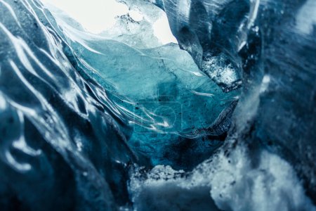Foto de Tapa de hielo congelada en cuevas de vatnajokull que se derriten debido al calentamiento global, rocas heladas de hielo que forman grietas masivas y túneles de senderismo de glaciares. Textura glacial transparente en bloques de hielo agrietados. - Imagen libre de derechos
