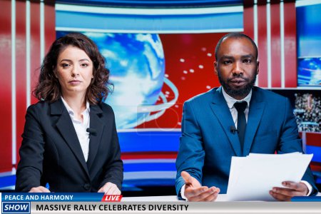 Photo for Newscasters present start of citizens rally, celebrating diversity in the city. Team of diverse broadcasters talking about pride parade modern event, creating tv reportage for peace and equality. - Royalty Free Image