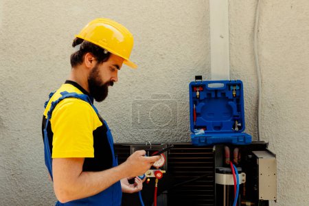 Photo for Professional worker ordering new internal parts for malfunctioning air conditioner after finishing review. Licensed serviceman tasked by client to look online for hvac system replacement components - Royalty Free Image