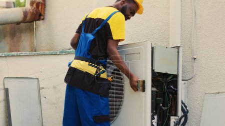 Photo for Capable specialist dismantling air conditioner in order to clean internal components. Proficient expert removing layer of dust from blower fan to prevent ventilation system malfunction - Royalty Free Image