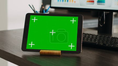Photo for Greenscreen projection on interactive tablet with chromakey theme appears on company desk. Isolated mockup design displayed on advanced handheld gadget, blank copyspace layout. Close up. - Royalty Free Image