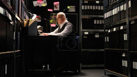 Photo for Private detective reading files, checking forensic evidence reports on classified documents in incident room. Law officer undertaking investigatory services with witness statements, uncover clues. - Royalty Free Image