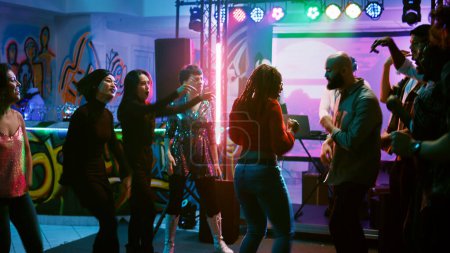 Téléchargez les photos : Funky personnes qui font bataille de danse pour montrer la musique électronique à la discothèque, s'amuser à la fête disco cool avec des danseurs. Des gens heureux improvisant une bataille de breakdance à l'événement. Coup de main. - en image libre de droit