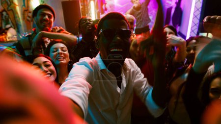 Photo for POV of funky people filming video at party, making memories on dance floor with friends at nightclub. Cheerful persons taking pictures and recording vlog at modern celebration. Handheld shot. - Royalty Free Image