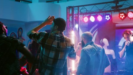 Téléchargez les photos : Jeunes dansant sur la musique disco, s'amusant avec des projecteurs et des mouvements de danse à la discothèque. Des gens joyeux profitant de rencontres sociales avec des amis et de spectacles sur scène. Trépied. - en image libre de droit
