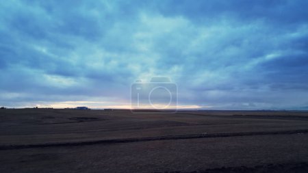 Photo for Aerial view of icelandic frosty fields in cold weather, fantastic arctic landscape with snowy mountains and colorful skies. Scandinavian countryside scenery with snow, scenic route. - Royalty Free Image