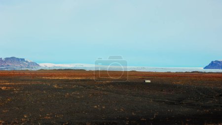 Photo for Beautiful countryside scenery with field and white snowy mountains on roadside, scandinavian landscapes with frozen hills. Fantastic icelandic nature with panoramic view. Handheld shot. - Royalty Free Image