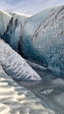 Foto de Masa de hielo glaciar Vatnajokull en la región nórdica, espectaculares rocas de hielo con grandes cuevas alrededor de la cadena montañosa nevada. Majestuosos icebergs congelados fragmentos flotando en el lago, ruta escénica. - Imagen libre de derechos