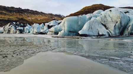 Foto de Enorme cadena de hielo glaciar vatnajokull, fantásticas rocas azules formando laguna glaciar cerca de lago congelado en iceland. Espectacular icebergs nórdicos con grietas y cuevas glaciares. - Imagen libre de derechos