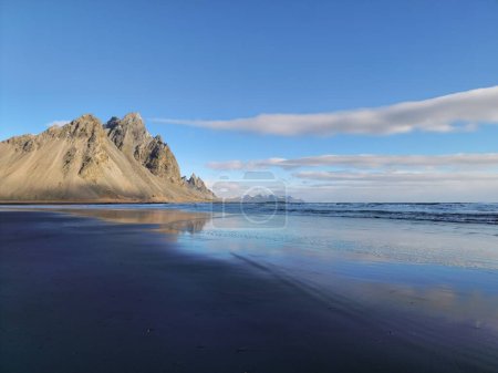 Téléchargez les photos : Stokksnes plage de sable noir avec crête de montagne du vestrahorn créant un magnifique panorama glaciaire. Majestueux littoral en bord de mer avec des collines sur la péninsule en iceland hivernal. - en image libre de droit
